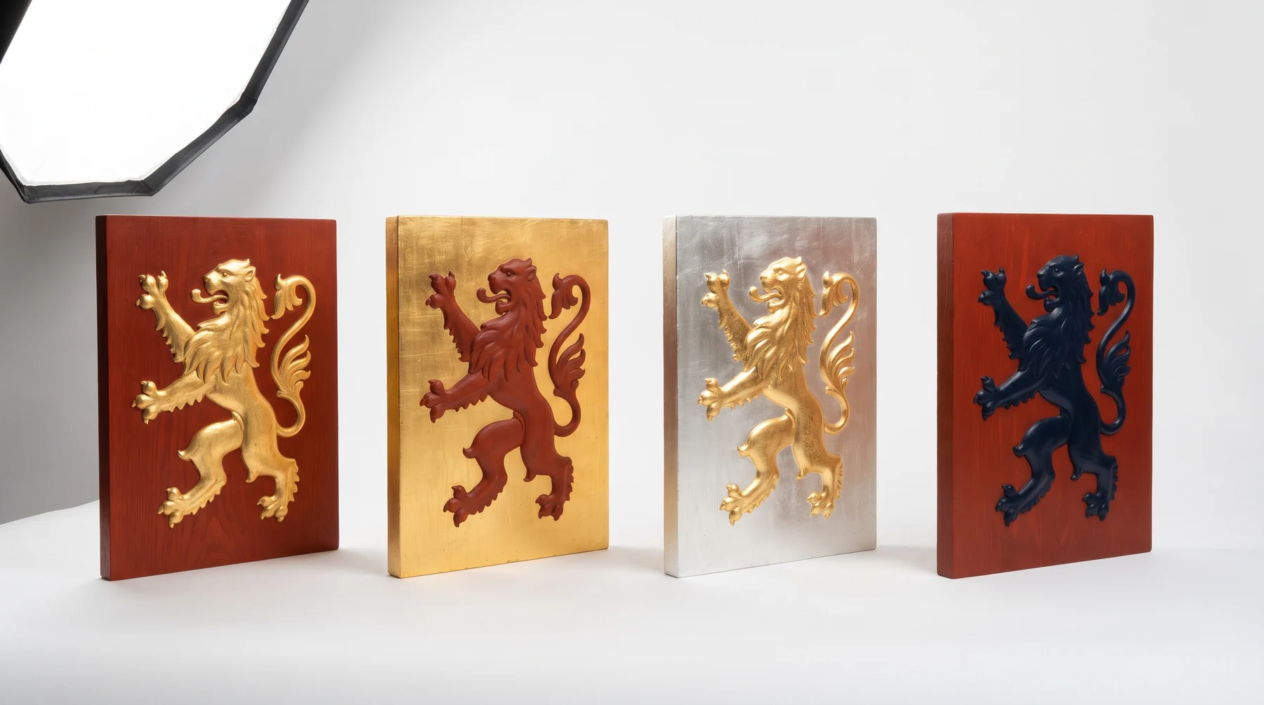 Four painted panels carrying the same lion in different colour pairings; the two on the right are hard to read because metal sits on metal and colour on colour